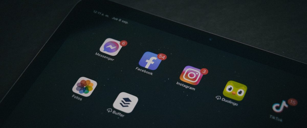 A tablet displaying popular apps like Facebook and Instagram in a dimly lit setting.